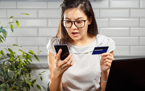 Fear and frustration - woman with a credit card and phone