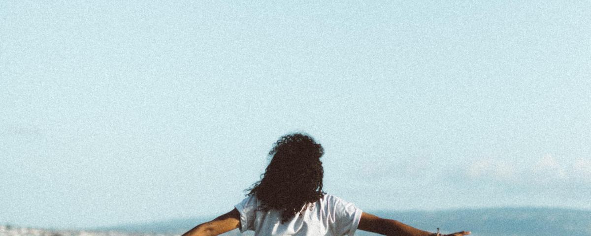 Person leaning against a rail in front of a lake