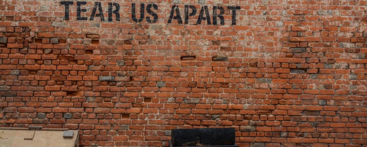 Wall that has writing "Until Debt Tear Us Apart"