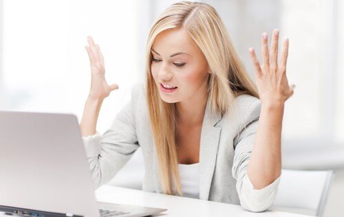 Young woman stressed out in front of a computer