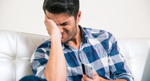 Man holding a credit card and stressed