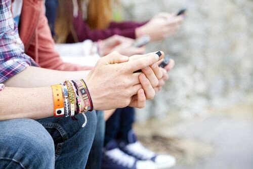Students sitting down on mobile phones