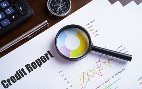 Study a credit report with a magnifying glass