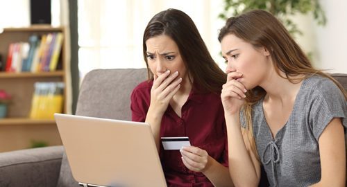 2 upset women holding a credit card
